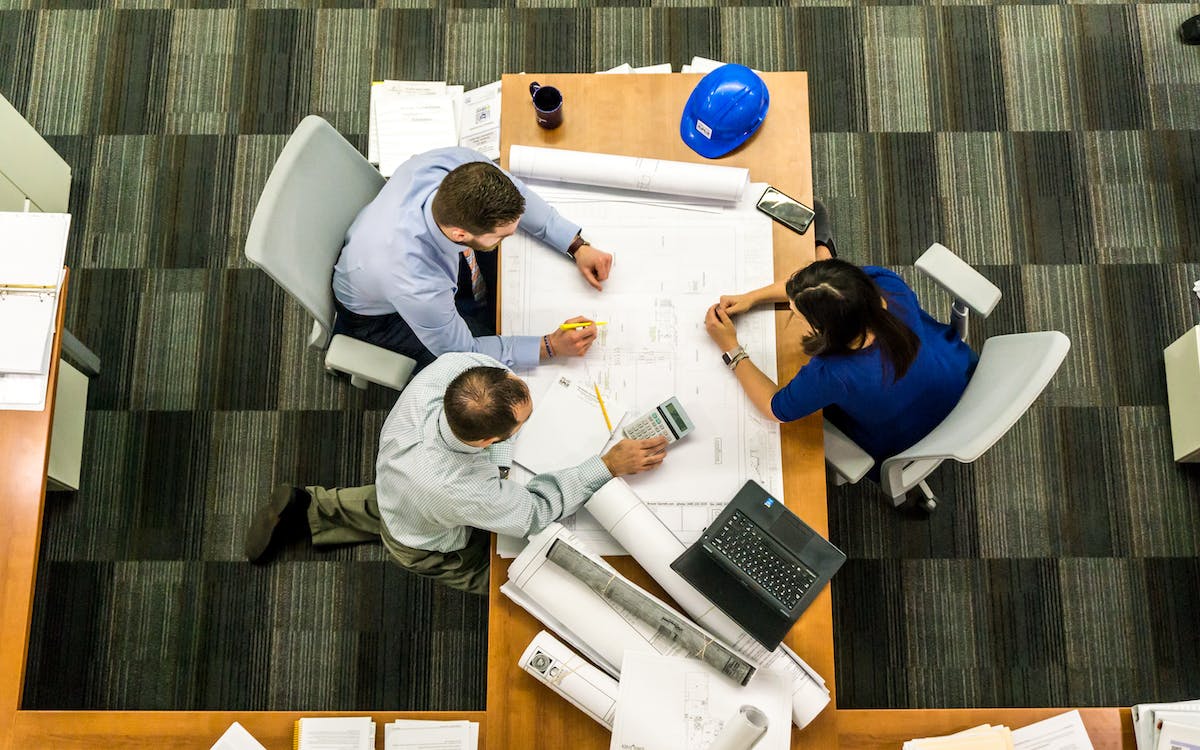 Equipe reunida em uma mesa analisando projetos