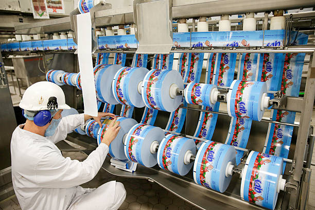 Operador inspecionando bobinas de rótulos em uma máquina